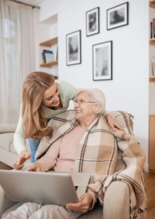 Middle-aged female teaching IT literacy to an aged lady