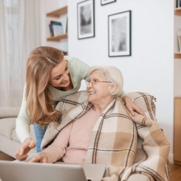 Middle-aged female teaching IT literacy to an aged lady